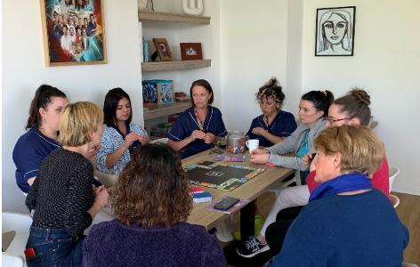Des professionnels et des bénévoles de la Maison de Nicodème en train de découvrir un jeu de plateau sur le musée d'art de Nantes avec une de ses médiatrices culturelles