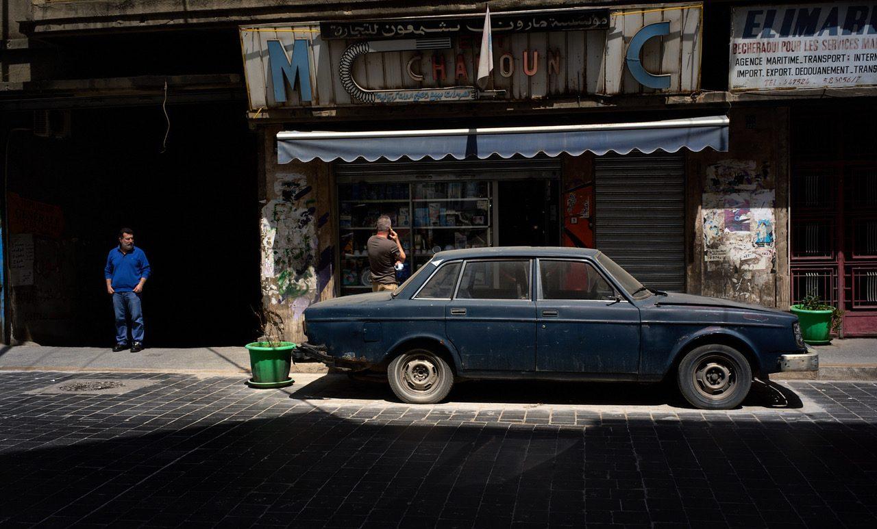 Rue de Beyrouth avec une voiture stationnée devant des commerces